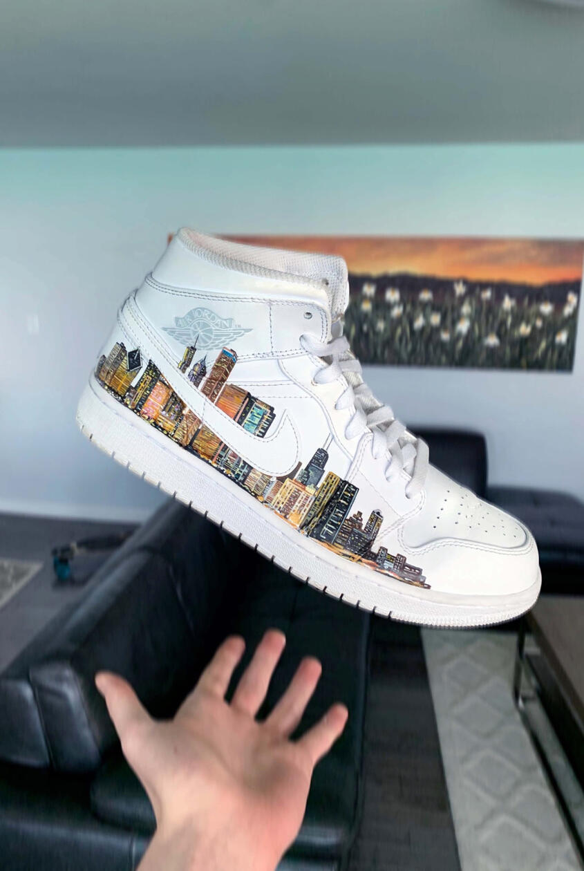 Custom Sneaker Art / Urban Cityscape · Acrylic leather paint on Nike sneakers, A custom pair created for a friend from Chicago, extending the city skyline across both shoes. Photo after completing the first half of the Chicago skyline on the shoe.